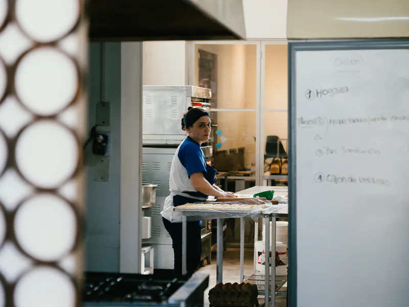 La cocina de honesto vista desde el salón, con la panadera trabajando