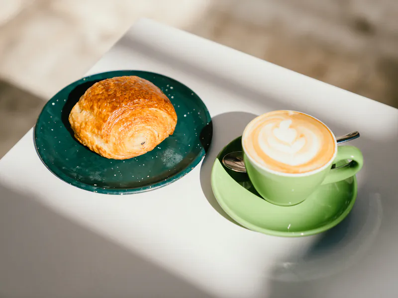 Medialuna de chocolate y café con leche en la mesa, desayuno en honesto