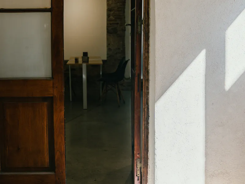 Puerta abierta de honesto con mesas y luz de la mañana adentro