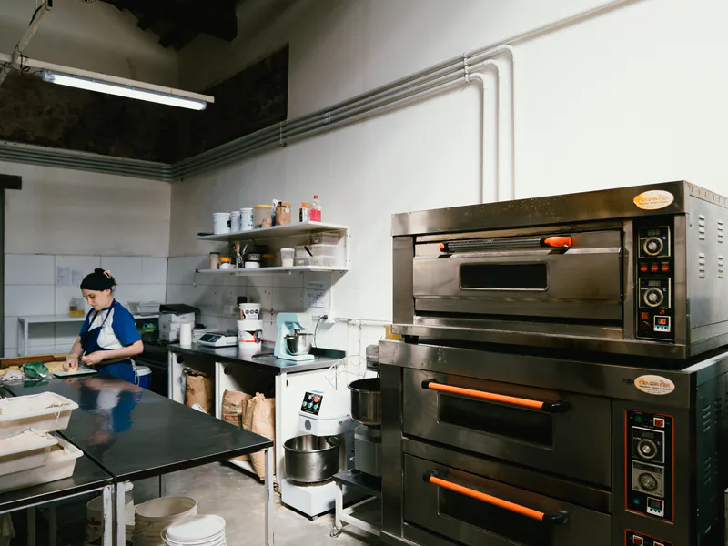 Panadera trabajando junto a los hornos de la cocina de honesto